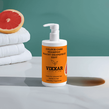 Vixxar Colour Care Shampoo in Peachy Grapefruit Zest bottle on table with grapefruit and towels in background.