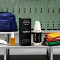 Vixxar Brightening & Pigment-Correcting Serums for dark spots on a locker room bench with packs and books