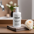 Vixxar Sensitive Scalp Shampoo 400ml for delicate skin, soothing and hydrating formula, bottle on towel with flowers in background.